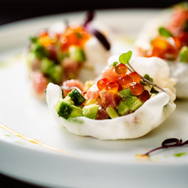 Close-up of tuna and avocado tartare with salmon roe in crispy rice paper cups.