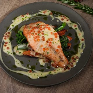 Salmon steak with creamy sauce, red caviar, broccolini and carrots